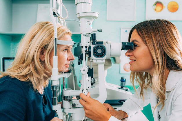 female optometrist giving an eye exam to a woman