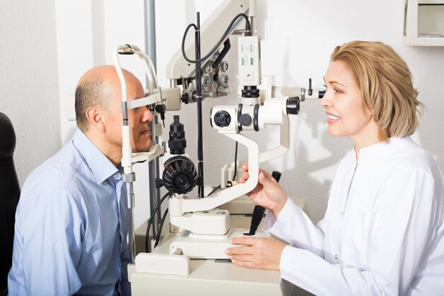 optometrist performing eye exam on a patient
