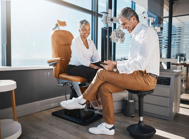 male eye doctor going over exam results with female patient